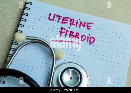 Concetto di fibroide uterino scrivere su libro isolato su tavolo di legno. Foto Stock