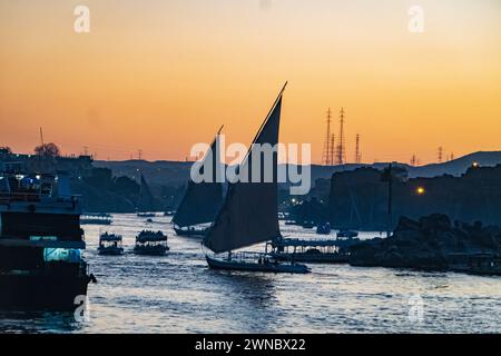 Barche e felucche a vela sul Nilo al tramonto ad Assuan, Egitto Foto Stock