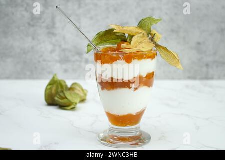 Un vasetto di vetro di dessert a strati con yogurt proteico e frutta di fitis Foto Stock