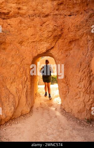 Una donna esce dal Tunnel attraverso Hoodoo nel Bryce Canyon Foto Stock