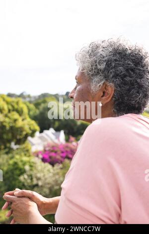 Donna birazziale anziana con capelli grigi che guarda in lontananza Foto Stock