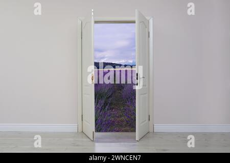 Porta aperta su una parete bianca che invita a visitare il campo di lavanda Foto Stock