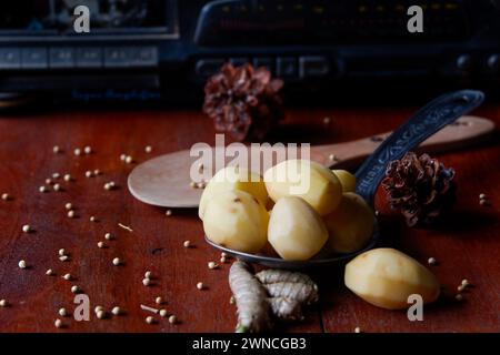 La foto è di spezie da cucina sotto forma di patate, curcuma, pepe bianco sullo sfondo di una vecchia radio Foto Stock
