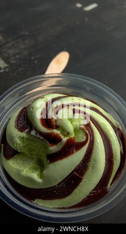 La foto è una foto di gelato al gusto di avocado in una tazza con sfondo nero Foto Stock