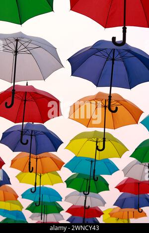 Ombrelli colorati e decorazioni urbane. Ombrelli colorati sospesi sul cielo blu, attrazione turistica, giornata di sole Foto Stock