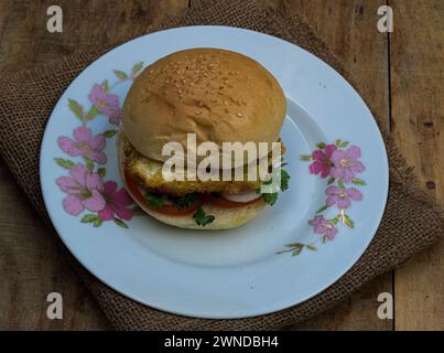 Primo piano hamburger di omelette. Piatto di verdure con hamburger d'uovo su sfondo di legno. Foto Stock