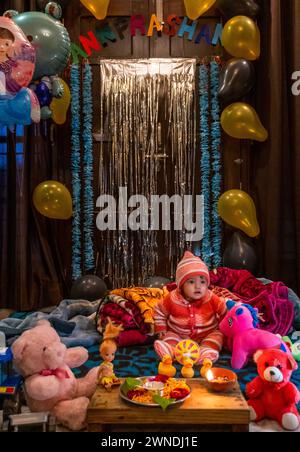 11 gennaio 2024, Uttarakhand India. Cerimonia Annaprashan: Primo pasto per bambine indiane con giocattoli e ciotola di riso Silver Kheer Foto Stock