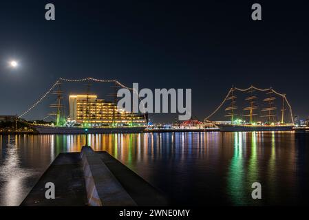 Navi a vela alte, Kaiwo Maru e Nippon Maru vestiti di luci durante il periodo natalizio nel porto di Kobe, in Giappone. Foto Stock