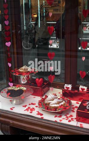 Vetrina adornata di cuori, con dolci e regali a tema San Valentino, ideale per esprimere amore e apprezzamento. Foto Stock