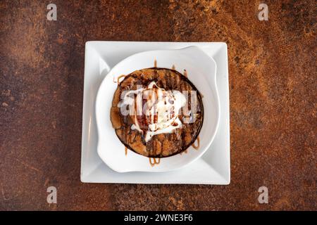Impasto per biscotti al cioccolato con salsa al cioccolato e gelato alla vaniglia Foto Stock