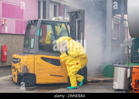 Einsatzkräfte in Schutzanzügen bei einem Gabelstaplerunfall mit austretenden Chemikalien bei Evonik als simuliertes Übungsszenario für 130 Einsatzkräfte der Großübung - Weiterstadt 02.03.2024: FFW Großübung bei Evonik *** servizi di emergenza in tute protettive durante un incidente con carrello elevatore a forche con perdite di sostanze chimiche a Evonik come scenario di esercizio simulato per 130 servizi di emergenza della grande esercitazione Weiterstadt 02 03 2024 FFW grande esercitazione a Evonik Foto Stock