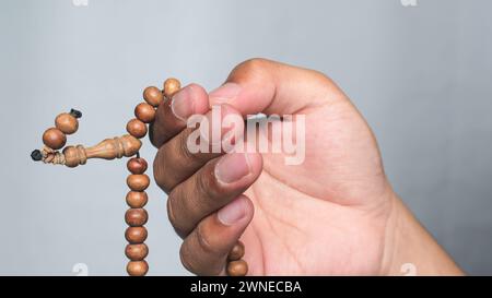 Mani che tengono le perle di rosario. Storia del Ramadan Kareem. Foto Stock