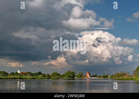 Vista della città di Loitz an der Peene con formazione di nuvole, parco naturale Flusslandschaft Peenetal, Meclemburgo-Pomerania Occidentale, Germania Foto Stock