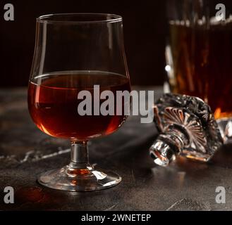 Primo piano di cecchino di brandy e decanter su fondo di legno Foto Stock