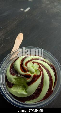 La foto è una foto di gelato al gusto di avocado in una tazza con sfondo nero Foto Stock