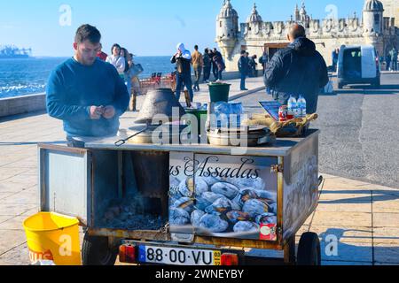 Uomo che vende castagne arrostite a Lisbona, in Portogallo Foto Stock