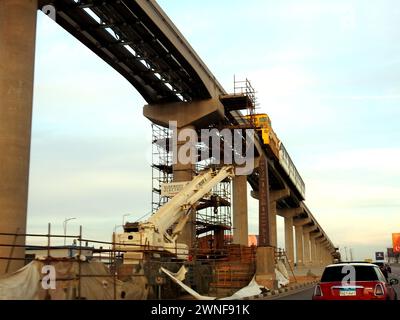 Cairo, Egitto, 22 febbraio 2024: Installazione di una monorotaia egiziana sul suo binario tramite una gru, la monorotaia del Cairo è una monorotaia a due linee con trasporto rapido S. Foto Stock