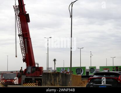 Cairo, Egitto, 23 febbraio 2024: Un camion gru mobile pronto per il sollevamento di oggetti pesanti in un cantiere in un raccordo autostradale in Egitto Foto Stock