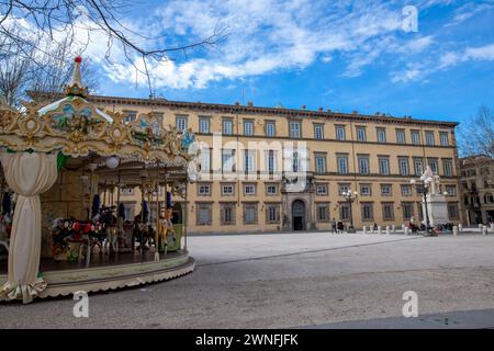 Colorata giostra di fronte al Palazzo Ducale in Piazza Napoleone nel centro storico della città medievale di Lucca, Italia Foto Stock