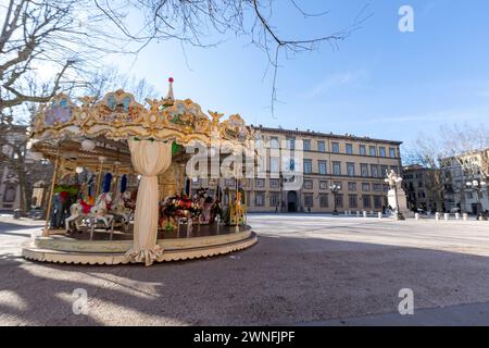 Colorata giostra di fronte al Palazzo Ducale in Piazza Napoleone nel centro storico della città medievale di Lucca, Italia Foto Stock