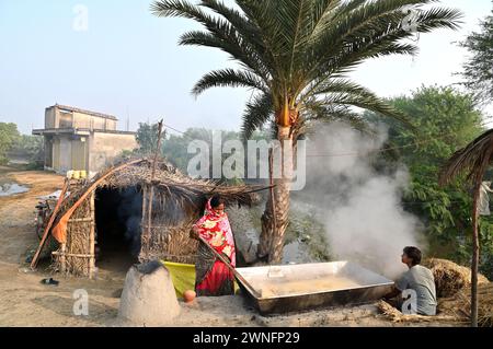 Datteri, jiggery di palme o khajoor gur, è una popolare prelibatezza invernale bengalese, fa bollire la linfa della palma da dattero per preparare il jiggery nel remoto villaggio. Foto Stock