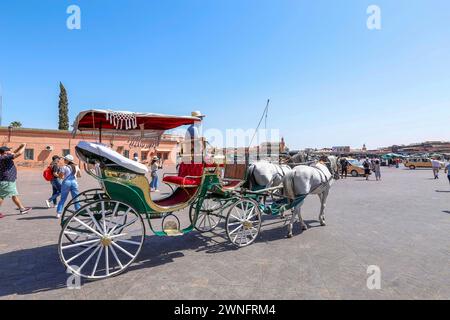 Marrakech, Morroco - 28 maggio 2019 - carrozza colorata e turisti nella tradizionale piazza Jamaa el Fna (anche Jemaa el-Fnaa, Djema el-Fna o Djemaa el-F. Foto Stock