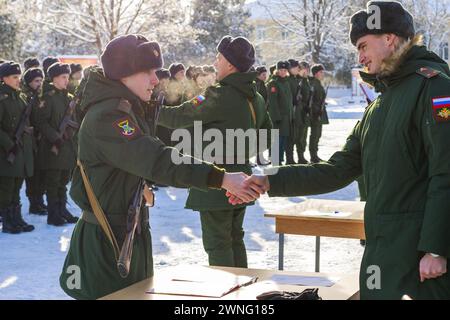 Maykop, Russia - 13 gennaio 2024: Un ufficiale stringe la mano a un giovane soldato che ha prestato giuramento militare sul terreno della parata di fronte a una linea di Foto Stock