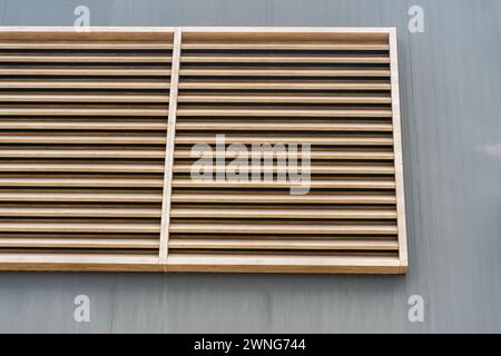 Eleganza della terra. tavole di legno di colore marrone chiaro sulla parete grigia . Edificio con facciata, sfondo. Foto Stock