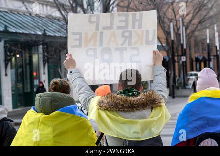 Ucraini alla piazza municipale di Calgary, con un cartello, segnano due anni dall'inizio della guerra. 24 febbraio 2024, Alberta, Canada. Foto Stock