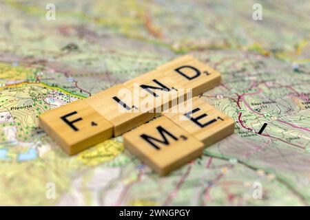 "Trovami" lettere di legno su una vecchia mappa di carta. Foto Stock