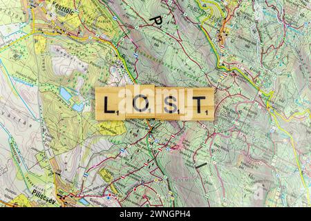 Lettere di legno perse su una vecchia mappa di carta. Foto Stock