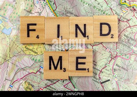 "Trovami" lettere di legno su una vecchia mappa di carta. Foto Stock