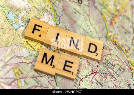 "Trovami" lettere di legno su una vecchia mappa di carta. Foto Stock