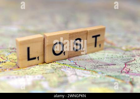 Lettere di legno perse su una vecchia mappa di carta. Foto Stock