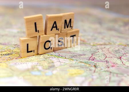 Lettere di legno perse su una vecchia mappa di carta. Foto Stock