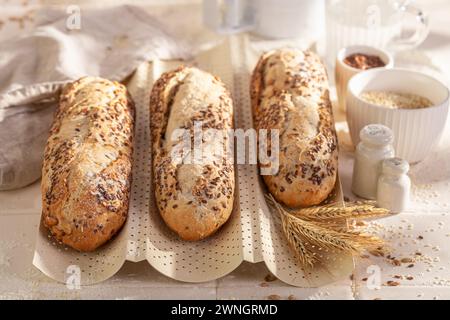 Baguette fatte in casa con semi di sesamo e lino. Baguette integrali in campagna. Foto Stock