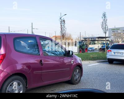 Kehl, Germania - 9 gennaio 2024: Una vista aerea cattura il traffico lento attraverso un ingorgo causato dai trattori che chiudono le strade di una città tedesca come protesta contro le politiche agricole più ecologiche, evidenziando l'impatto sulla vita urbana e sui trasporti Foto Stock