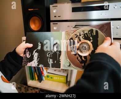 Parigi, Francia - 17 gennaio 2024: A Young child detiene la versione SACD di Aftermath dei Rolling Stones, sfogliando nel suo libretto Foto Stock