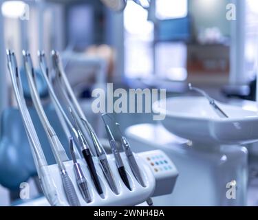 Una raccolta di strumenti dentali ordinatamente disposti in fila accanto a un lavandino in un ambiente clinico. Foto Stock