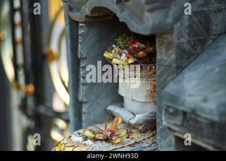 Scultura di un tempio con fiori e incenso per offerte rituali sulla popolare isola turistica di Bali Foto Stock