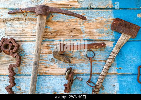 Collezione di antichi utensili da minatore arrugginiti esposti sulla parete di una baracca Foto Stock