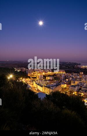 Al crepuscolo e all'ora blu dal punto panoramico di Guardiola sopra la città di la Ràpita (ex Sant Carles de la Ràpita) nel Delta dell'Ebro. Tarragona, Spagna Foto Stock