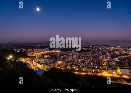 Al crepuscolo e all'ora blu dal punto panoramico di Guardiola sopra la città di la Ràpita (ex Sant Carles de la Ràpita) nel Delta dell'Ebro. Tarragona, Spagna Foto Stock