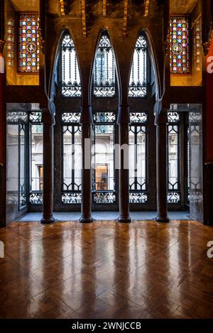 Sala visitabile del palazzo Palau Güell, con uno spettacolare soffitto in legno e finestre con archi parabolici e colonne (Barcellona, Catalogna, Spagna) Foto Stock