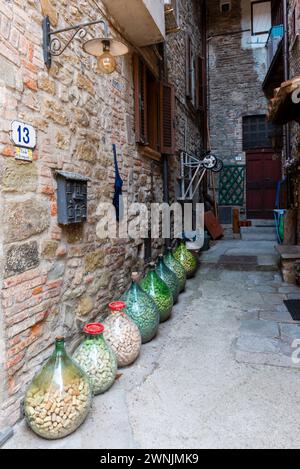 Bottiglie addossate piene di sughero in un cortile nel centro storico di Passignano sul Trasimeno, Umbria, Italia Foto Stock