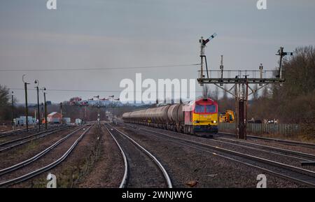 DB Cargo classe 60 locomotiva diesel che trasporta un lungo treno di serbatoi di olio attraverso i segnali del semaforo meccanico a Wrawby Junction, Barnetby Foto Stock