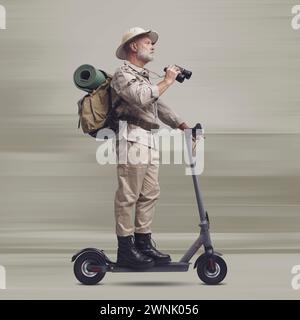 Funny explorer a bordo di uno scooter elettrico veloce e con binocolo Foto Stock