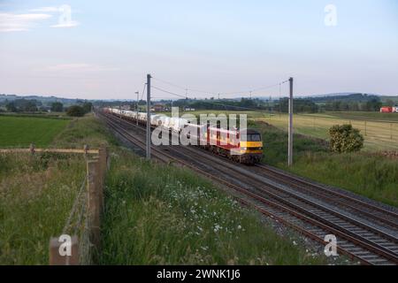 Un treno merci DB Cargo trainato da 2 locomotive elettriche classe 90 che trasportano nuovi veicoli a motore Ford passa Plumpton sulla linea principale della costa occidentale Foto Stock