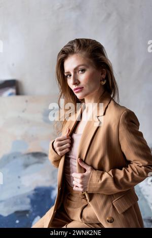 Bella e attraente giovane donna con un leggero abito beige Foto Stock