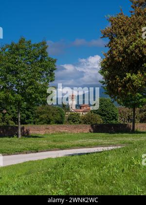 Vista dell'antico campanile della chiesa di Sant'Anna dal parco delle antiche mura della città di Lucca Foto Stock